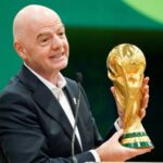 Infantino holding the World Cup trophy at a press conference