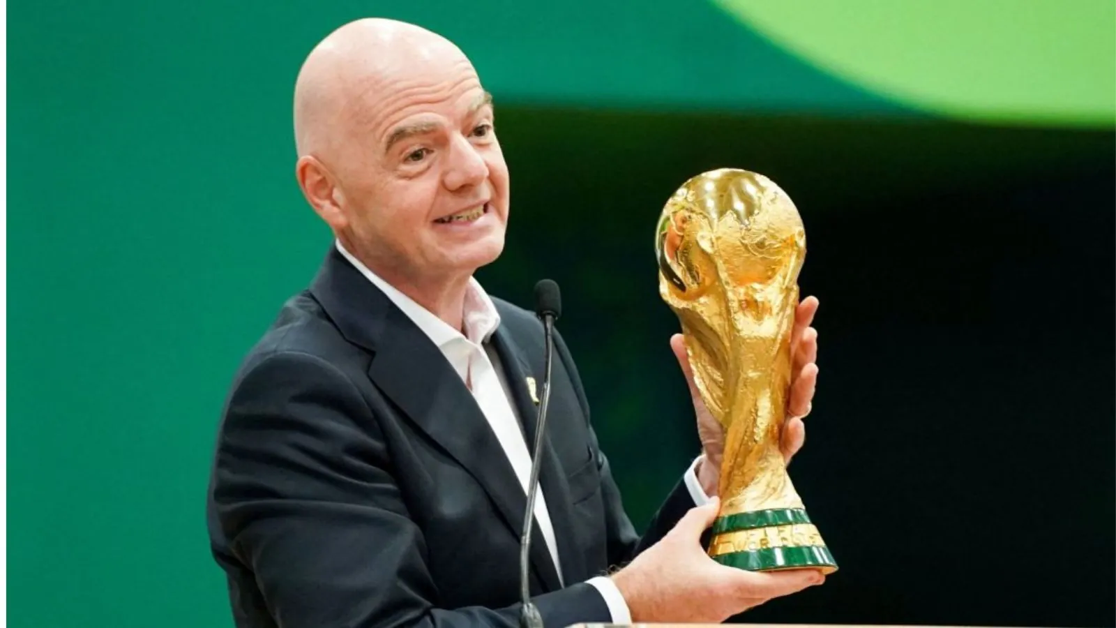 Infantino holding the World Cup trophy at a press conference