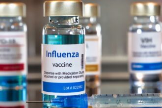 A table displaying several vials of influenza vaccine arranged neatly in a clinical setting