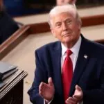 Donald Trump looking at the United States flag as a symbol of respect for his nation