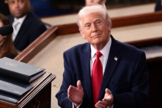 United States escalates trade war with Canada and threatens new 50% tariffs Donald Trump looking at the United States flag as a symbol of respect for his nation