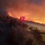 United States evacuates more than 40,000 people as massive wildfire spreads near Reno A pickup truck driving through a path with intense fire after the wildfire