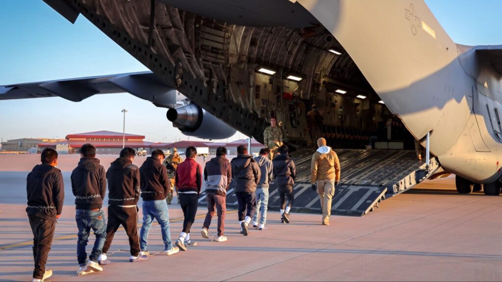 "A large airplane receiving several deported individuals to transport them back to their home country
