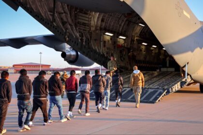 "A large airplane receiving several deported individuals to transport them back to their home country
