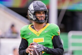 Dante Moore emerges as the favorite to be the top quarterback in the 2027 NFL Draft The young pitcher smiling at the cameras while holding his helmet