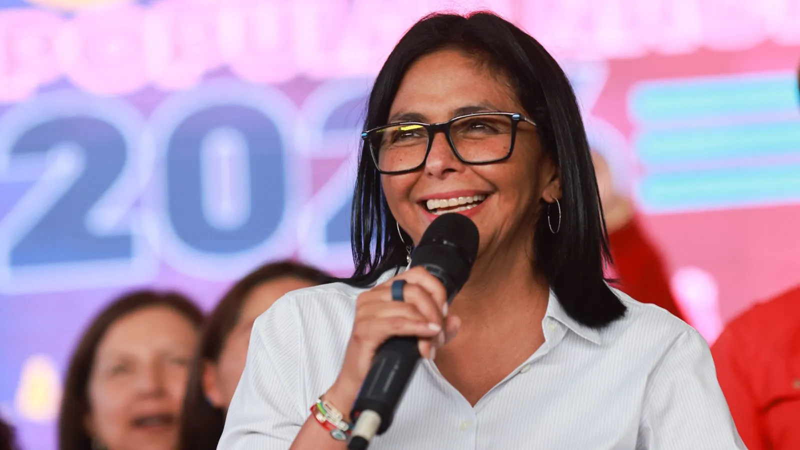 Delcy Rodríguez says Venezuela will hold elections but gives no date Venezuela’s current leader smiling broadly while being applauded and accompanied by her supporters