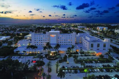 A well-known hospital in Florida with many cars parked outside and all its lights turned on