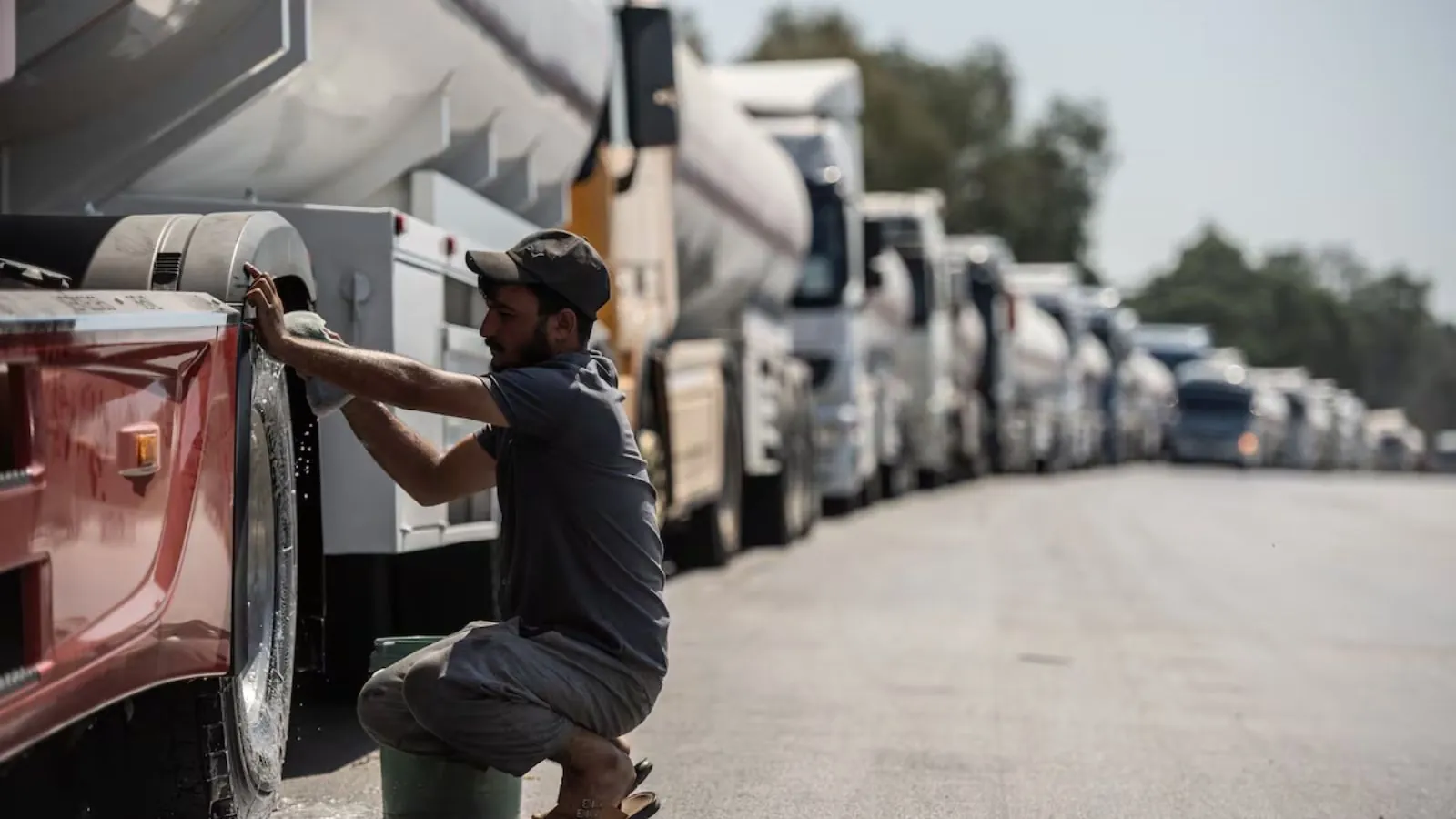 Fuel prices soar worldwide as protests erupt over rising energy costs A long line of tractor-trailers following road closures in Portugal