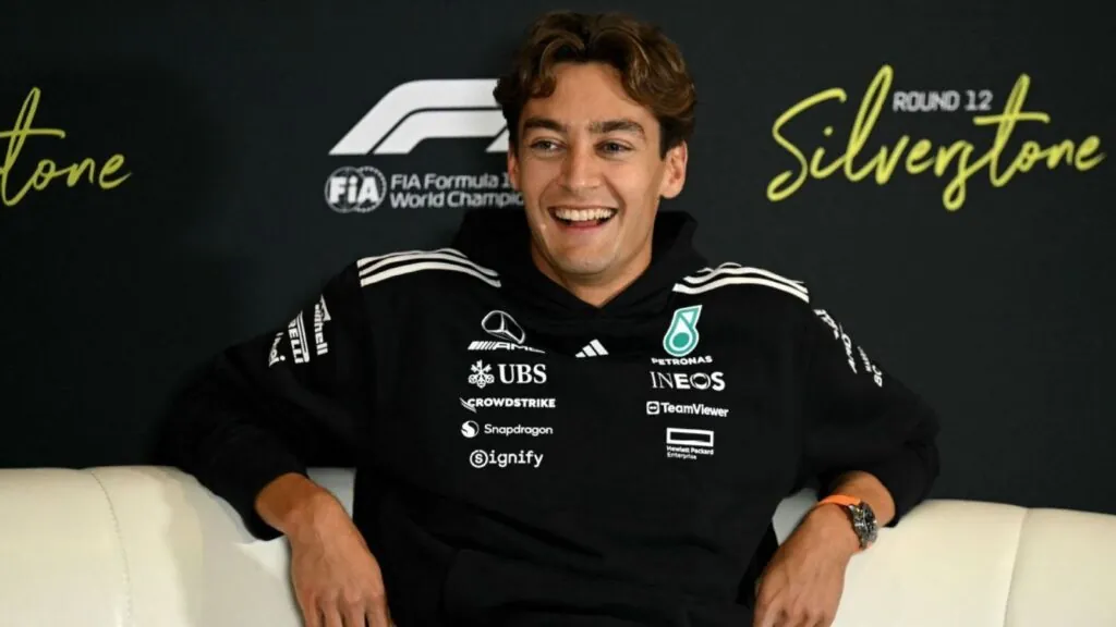 The Mercedes driver sitting on a couch and smiling at the cameras