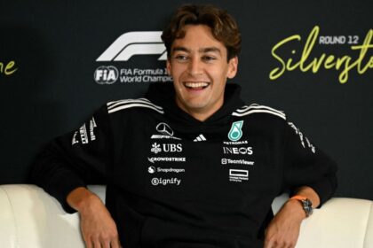 The Mercedes driver sitting on a couch and smiling at the cameras