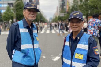 Japan breaks historic record with more than 100,000 centenarians Two elderly men working as traffic guards