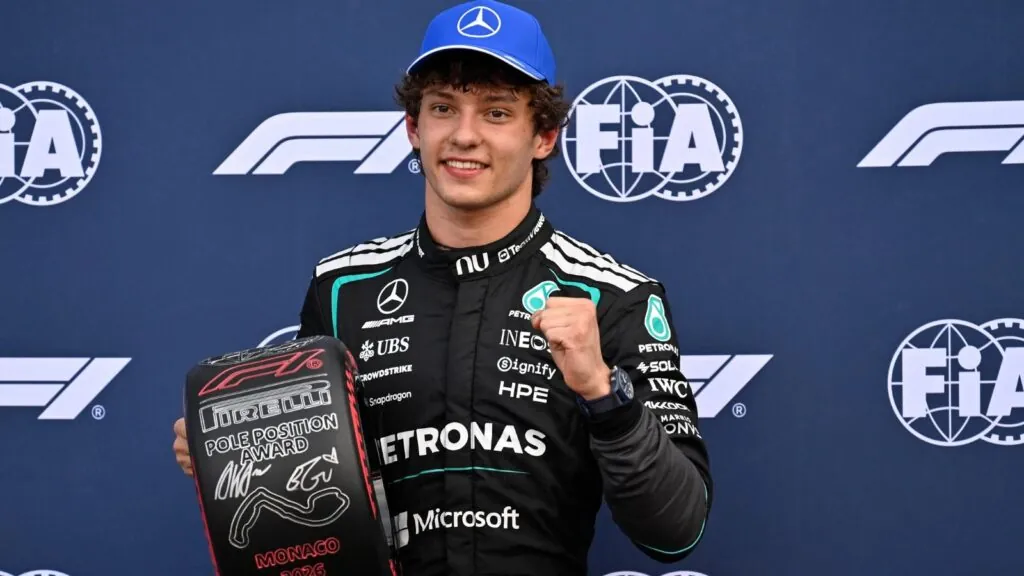 The Italian driver celebrating with his trophies while being photographed