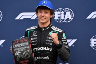 The Italian driver celebrating with his trophies while being photographed