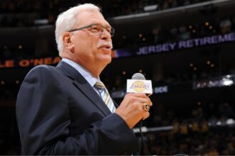 The legendary coach speaking into a microphone during a Lakers game