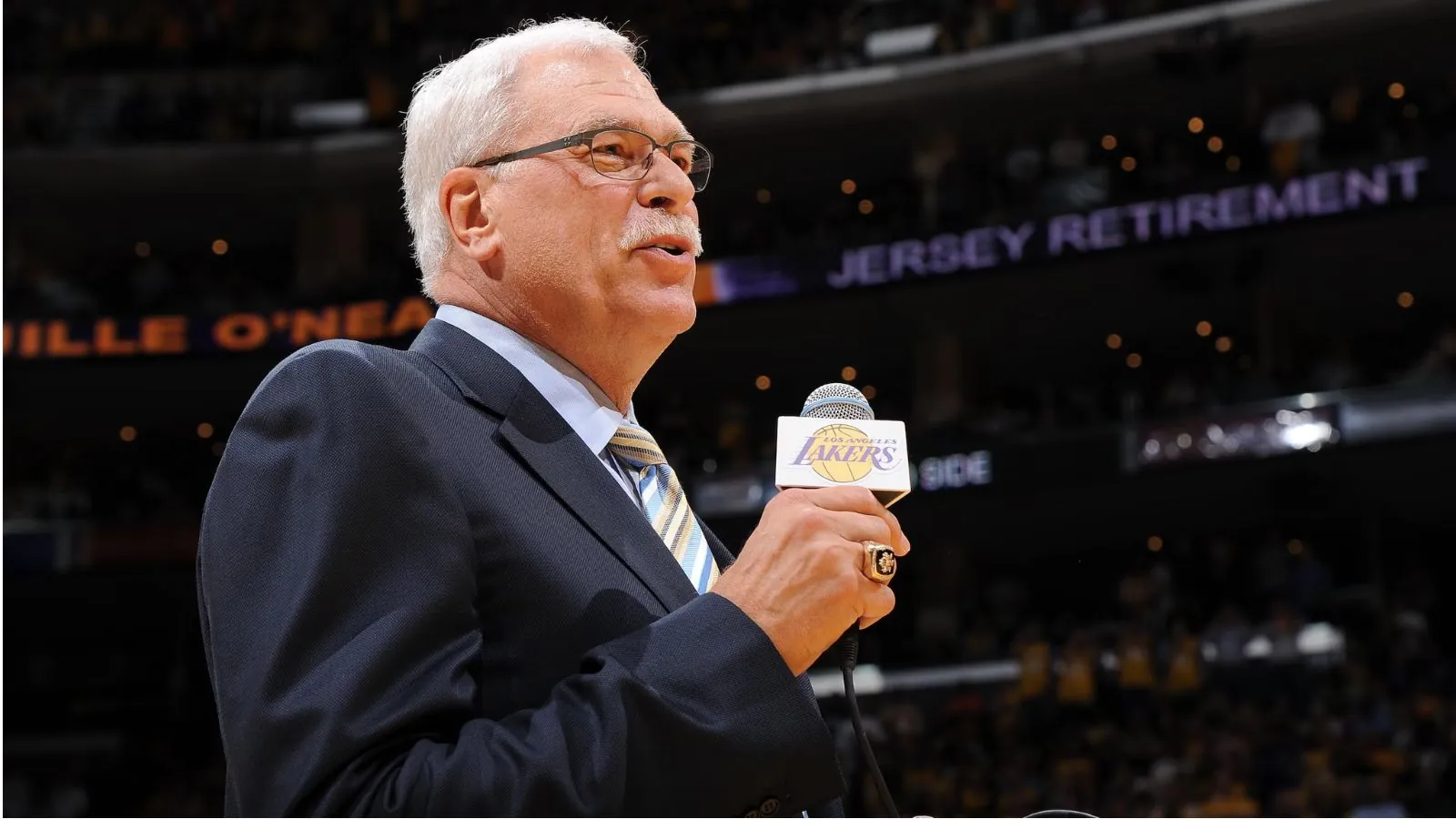 Lakers honor Phil Jackson with a statue after his historic championship legacy The legendary coach speaking into a microphone during a Lakers game