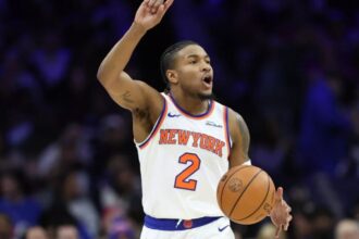 The important NBA point guard raising his index finger while signaling a new play to his teammates