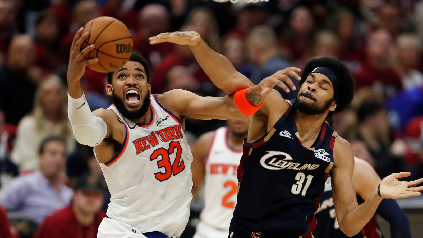 A Knicks player and a Cavaliers player battling under the basket
