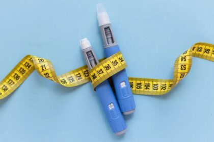 Two medication needles surrounded by a measuring tape symbolizing weight loss