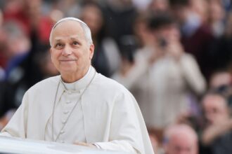 Pope Leo XIV riding in his carriage while greeting everyone present during one of his visits