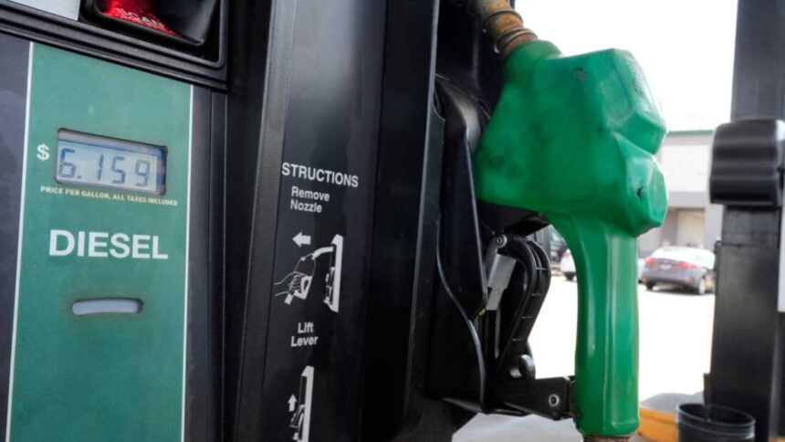 A green diesel fuel pump with the product prices displayed on one side