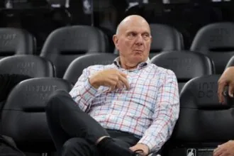 The owner of the Los Angeles Clippers sitting in a chair while watching his team practice