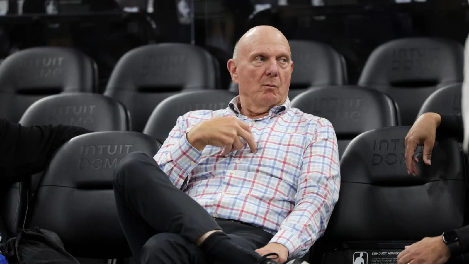 The owner of the Los Angeles Clippers sitting in a chair while watching his team practice