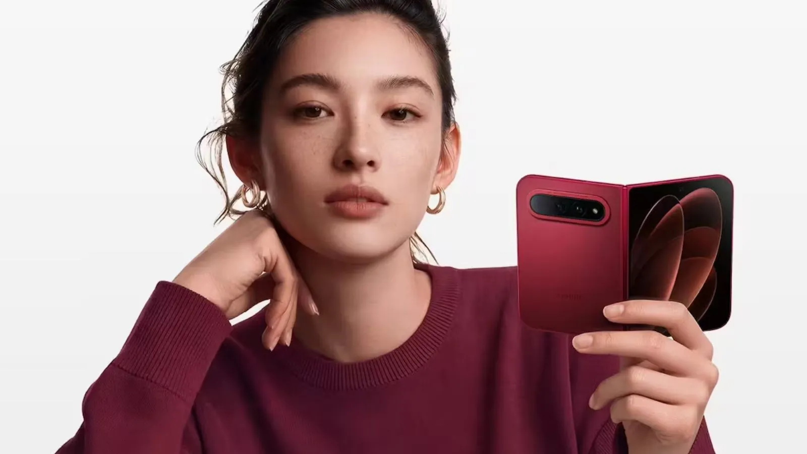 Xiaomi unveils the 18 Fold: A powerful new passport-style foldable phone A young Asian woman holding the new red Xiaomi phone